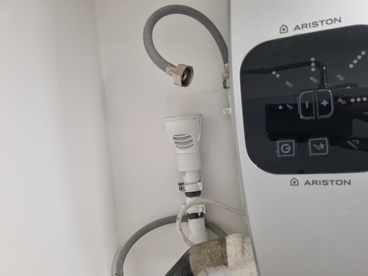 Groupe de sécurité et flexibles raccordés sur un chauffe-eau Ariston