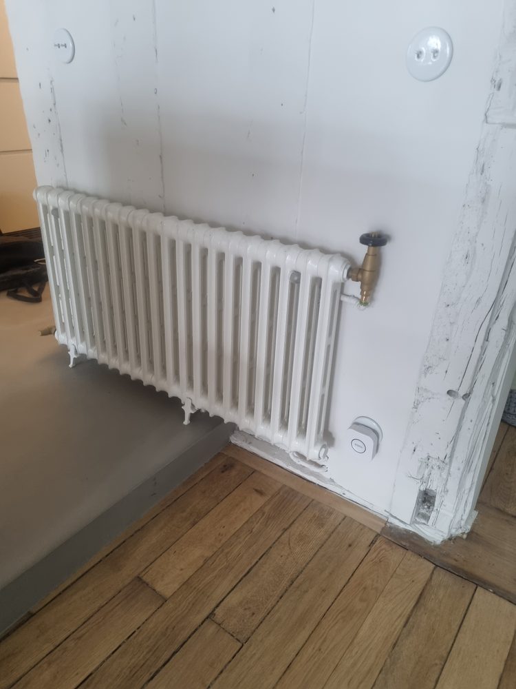 Radiateur fonte à colonnes basses raccordé avec robinet laiton en angle de pièce