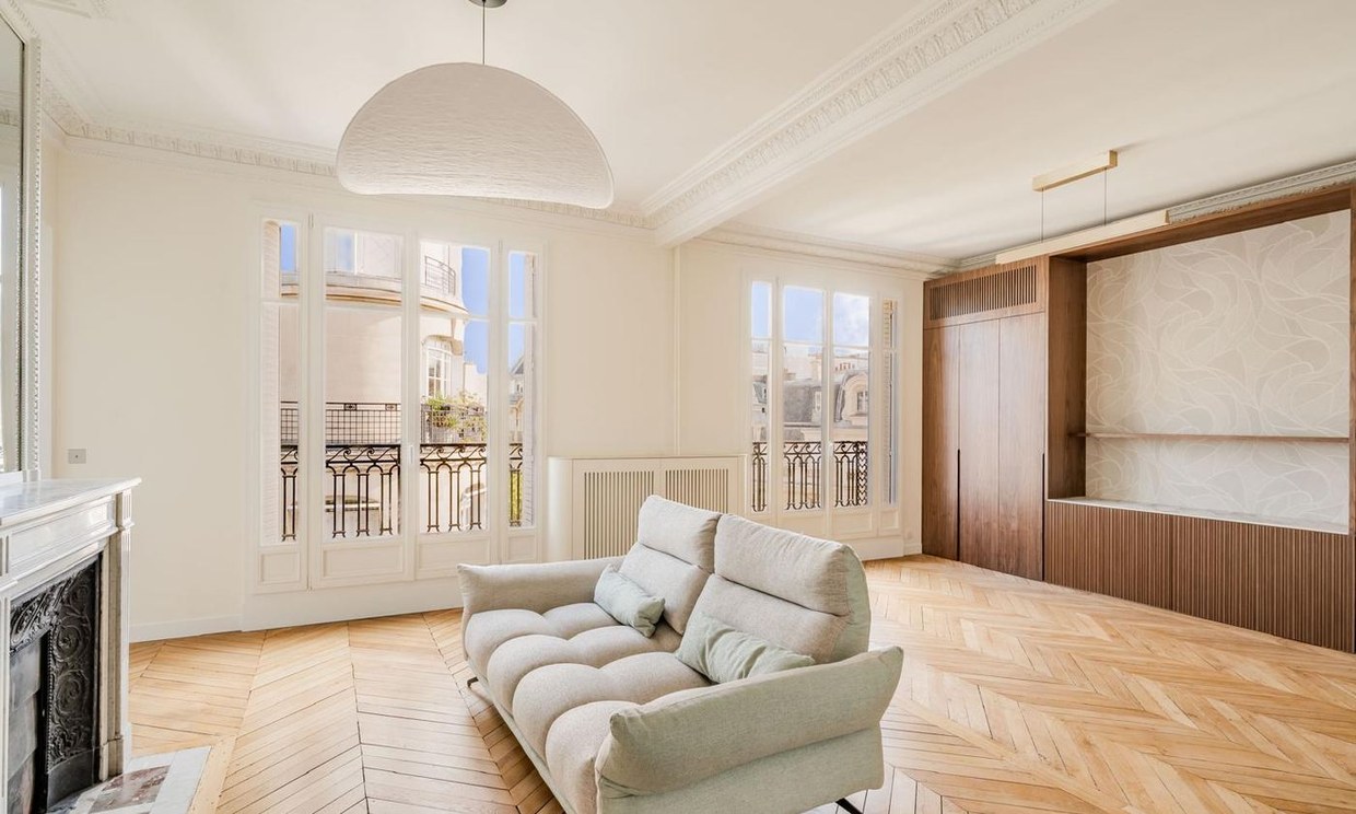 Séjour haussmannien rénové : cheminée de marbre, moulures et parquet à chevrons