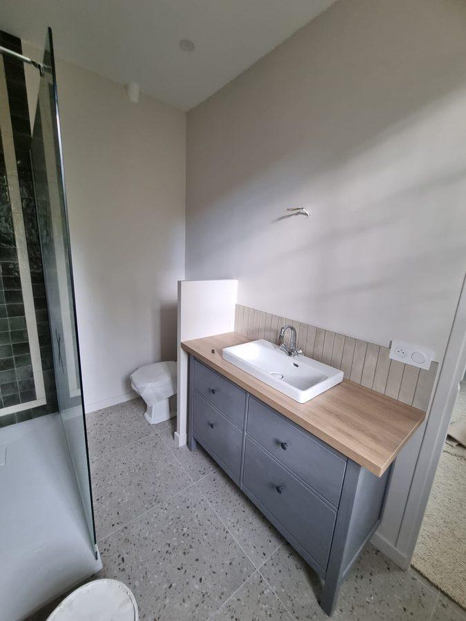 Salle de bain rénovée clé en main : douche zellige noir, meuble vasque et sol terrazzo