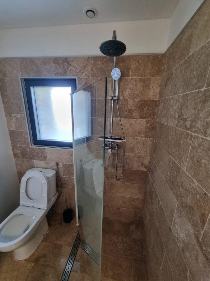 Salle d'eau en travertin avec douche à l'italienne et caniveau inox