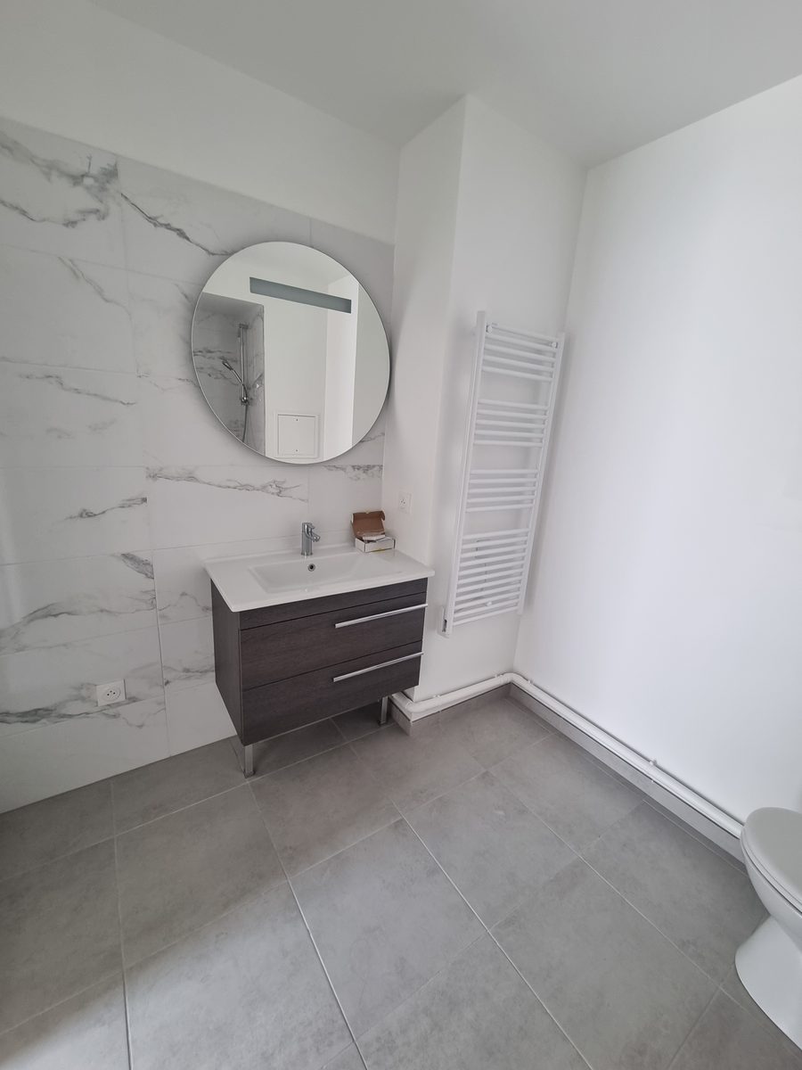 Salle de bain complète en marbre avec douche à porte coulissante et WC suspendu