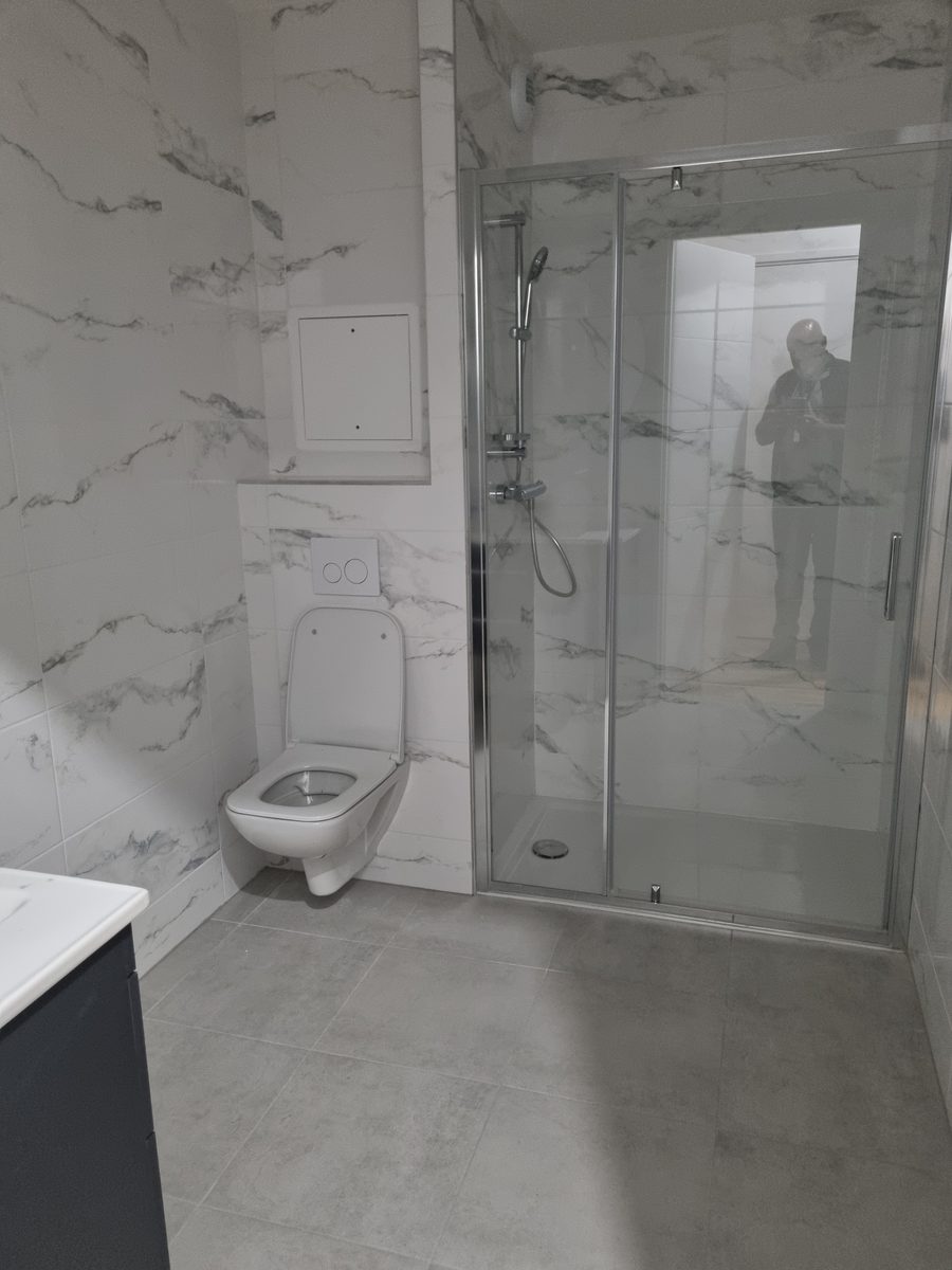 Douche avec paroi vitrée et WC suspendu en faïence effet marbre