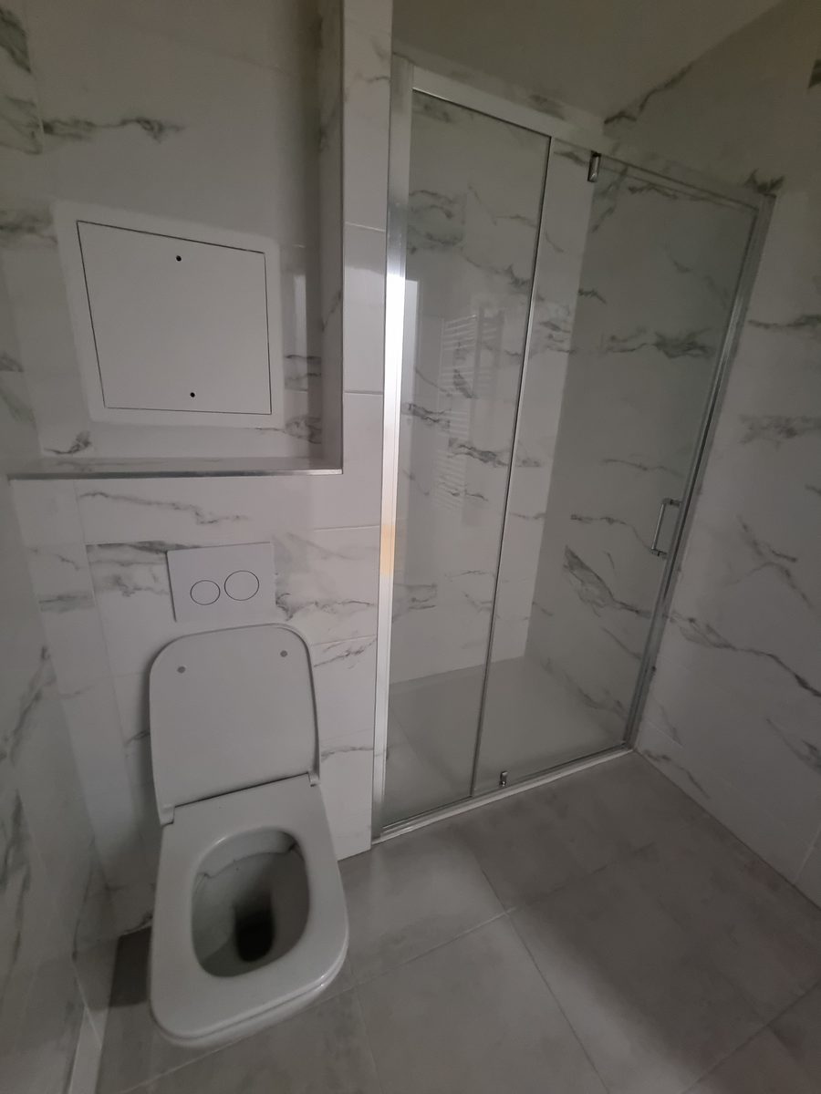 WC suspendu et meuble vasque dans une salle de bain effet marbre