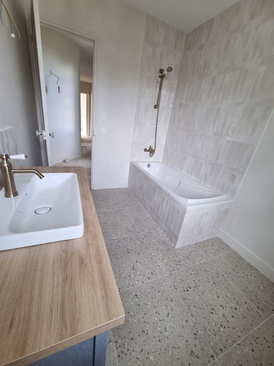 Baignoire encastrée habillée de faïence zellige avec sol terrazzo