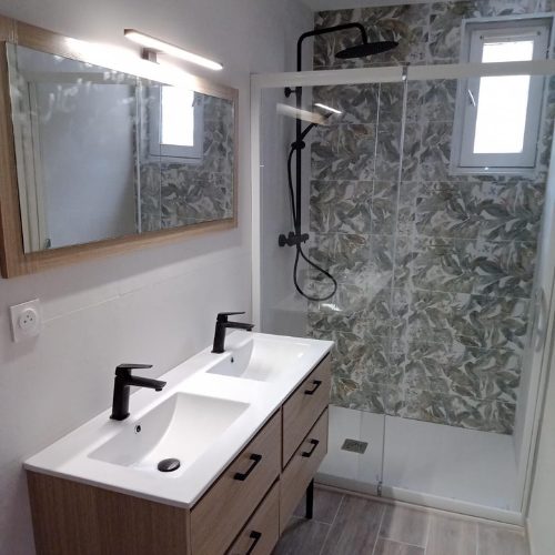 Meuble double vasque suspendu et grand miroir dans une salle de bain effet marbre