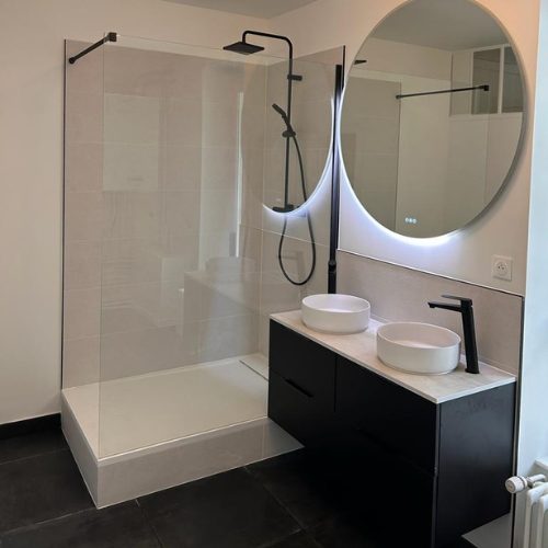 Douche à l’italienne, meuble vasque noir et miroir rond rétroéclairé