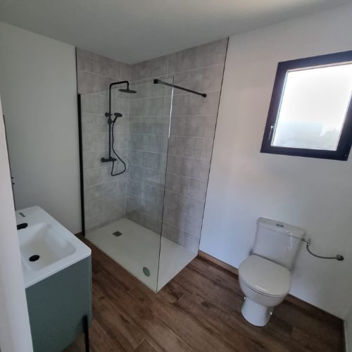 Douche à l’italienne et WC dans une salle d’eau claire