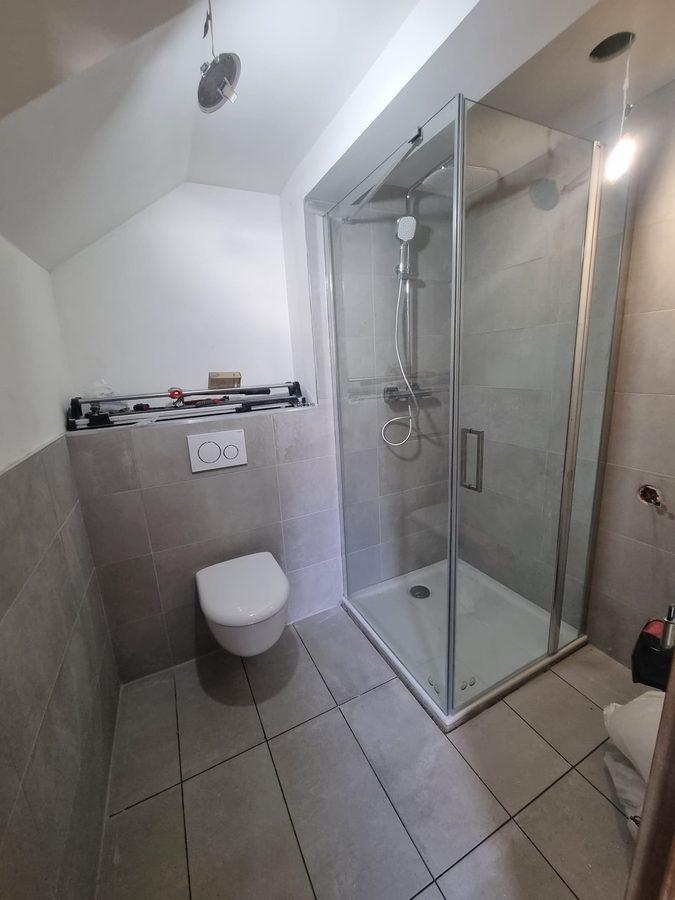 Salle d'eau créée sous comble avec WC suspendu et cabine de douche